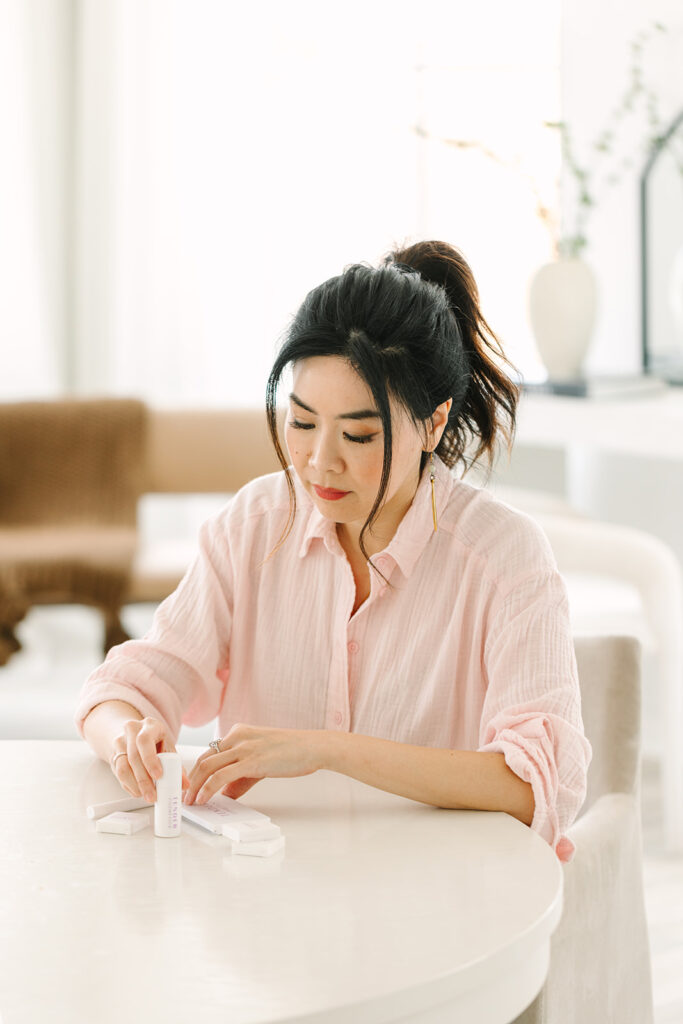 Beauty brand founder handling product samples during a professional brand photoshoot.