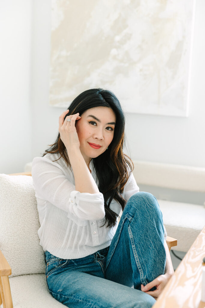 Portrait of a female entrepreneur seated comfortably in a bright, modern space during a brand photoshoot.