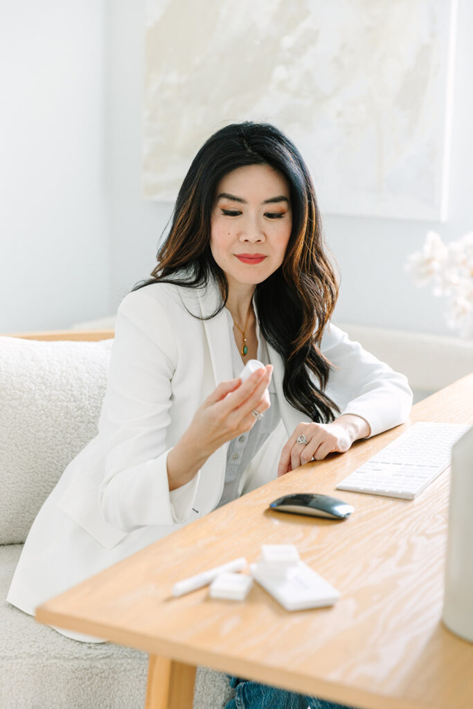 Beauty brand founder testing products at her desk during a professional photoshoot.